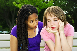 girl being comforted by her friend.