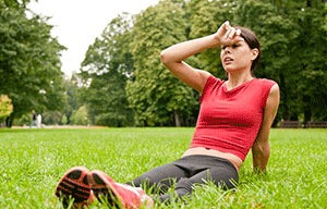 A an exhausted girl sitting in the grass.