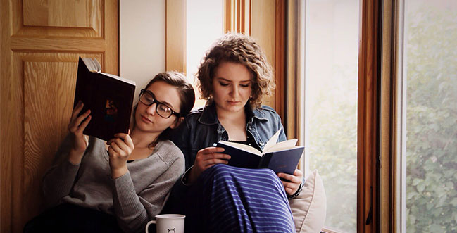 Girls reading books by a window