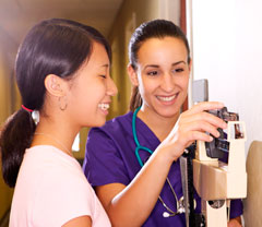 A nurse weighing a girl on a scale.