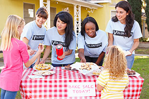 Girls volunteering at a bake sale.