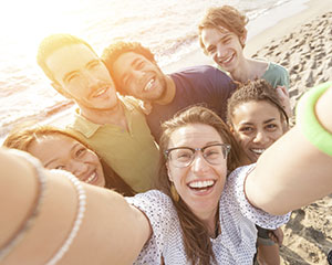 A group of friends taking a selfie at the beach.