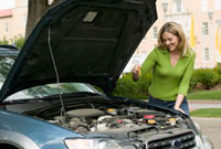 A girl changing the oil in her car.